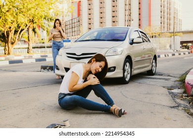 Asian Woman Was Hit By A Car While Crossing The Road And Sitting On The Floor Injured Legs And Knees. Walking Knee Pain Unable To Walk With Painful Face : Female Driver Looked Shocked And Guilty.
