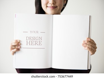 An Asian woman is holding a blank magazine