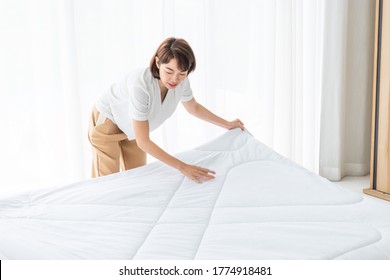 Asian Woman Holding Blanket To Make A Bed