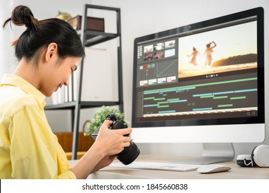 Asian woman holding a camera and using application video editor works on the computer with footage on wooden table. - Powered by Shutterstock