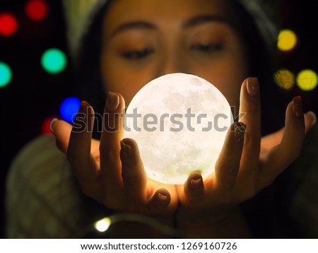 Asian Woman Holding Illuminated String Lights While laying on her bed,Christmas night concept.