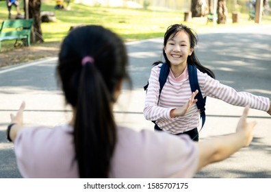 Asian Woman Holding Opened Arms And Child Girl Daughter Missed Her Mom Running To Mother Standing In Outdoor At Primary School, Female Teenage Running To Hug Her Mother With Love After Back School