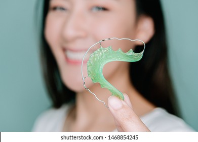 Asian Woman Holding Orthodontic Retainers.Teeth Retaining Tools After Braces .