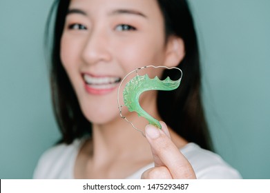 Asian Woman Holding Orthodontic Retainers.Teeth Retaining Tools After Braces .