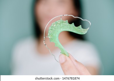 Asian Woman Holding Orthodontic Retainers.Teeth Retaining Tools After Braces .