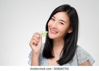 Asian Woman Holding Orthodontic Retainers.Teeth Retaining Tools After Braces .

