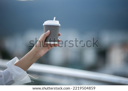 Asian woman holding a paper cup drinking coffee showing on clear sky natural morning sunlight Space Place for your text or logo empty space for text