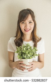 Asian Woman Holding Plant