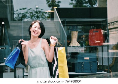 Asian Woman Holding Shopping At Outlet Mall.Beautiful Asian Woman In Casual Dress With Shopping Bag.