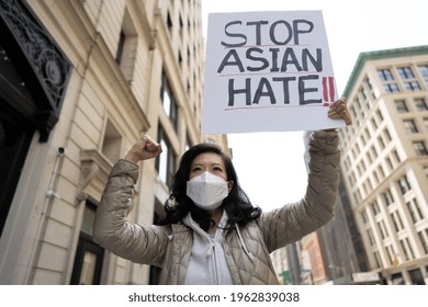 Asian woman holding Stop Asian Hate sign protesting on a street in New York City - Shutterstock ID 1962839038