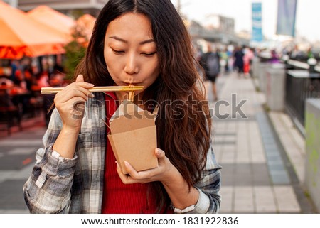 Asian Woman Holding A Street Food in city.