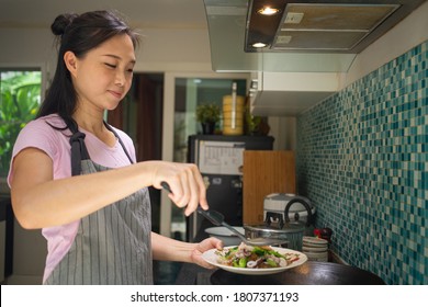 Asian Woman Holding  Tasty Cook Dishes In The Kitchen.Smelling Delicious Seafood Noodle With Vegetables .Smiling Satisfaction With Her Meal.