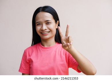 Asian Woman Holding Up Two Fingers Means Fight