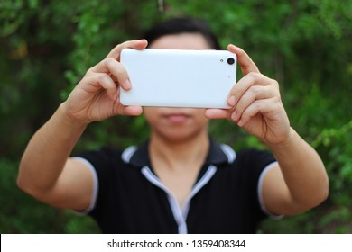 Asian Woman Holding And Using Smart Phone Show Back Side.
