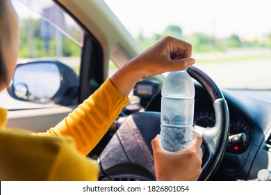 Asian Woman Holding A Water Bottle For Drink While Driving The Car In The Morning During Going To Work On Highway Road, Transportation And Vehicle Concept