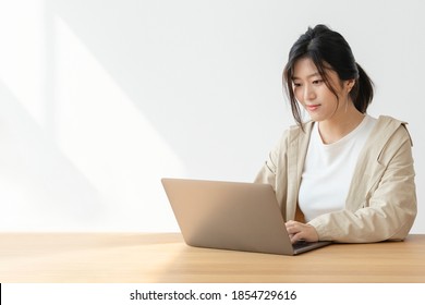 Asian Woman At Home Using A Laptop