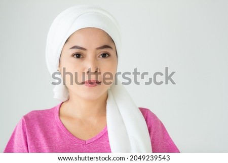 Asian woman as hospital patient for breast cancer treatment looks lively and cheerful on pink casual shirt cover head by white clinical scarf to dry hair after bath