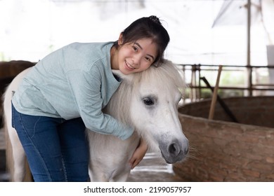 Asian Woman Hug Dwarf Horse In A Farm