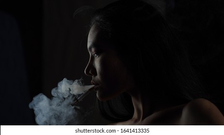 Asian Woman Inhaling And Cigarette Vaping. Female Secretly Smoking In Bathroom At Home. Concept Of Quit Smoking And Anti Cigarette.