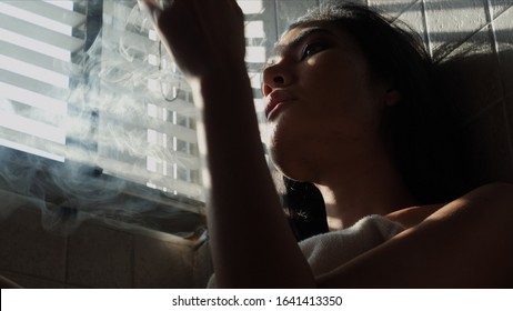 Asian Woman Inhaling And Cigarette Vaping. Female Secretly Smoking In Bathroom At Home. Concept Of Quit Smoking And Anti Cigarette.