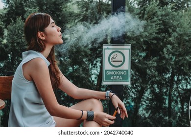 Asian Woman Inhaling And Cigarette Vaping. Female Secretly Smoking In Bathroom At Home. Concept Of Quit Smoking And Anti Cigarette.
