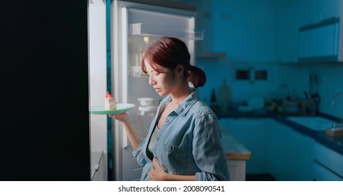 Asian Woman Intending To Lose Weight So She Can Not Eat Cake In Kitchen At Night