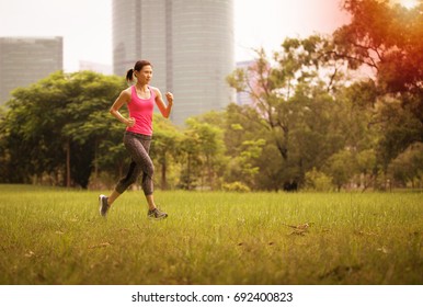 An Asian Woman Jogging In The Park