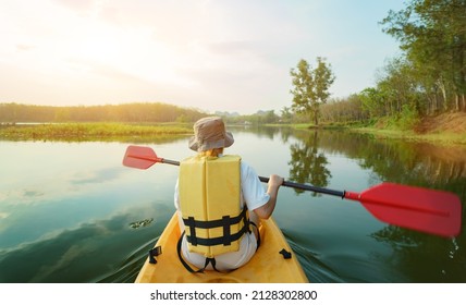 Asian woman kayaking on lake alone. Summer camp and solo outdoor activity - Powered by Shutterstock