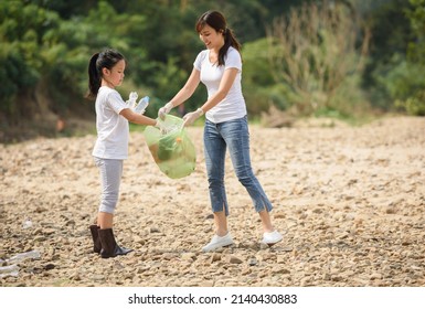 Asian Woman And Kid Girl Of Volunteer People Collecting Trash. Ecology Charity And Clean Environment Earth Day Concept.