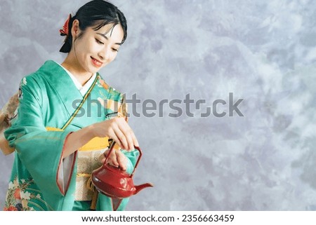 Asian woman in kimono holding a Japanese sake pot. Japanese restaurant waitress. Japanese new year celebration.