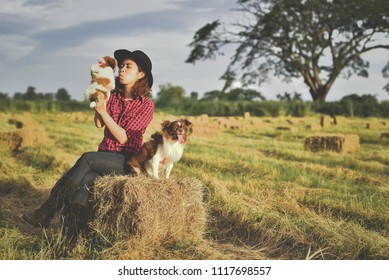 Asian Woman Kissing Her Dog In The Garden; Outdoor In Nature.