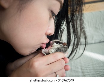 Asian woman is kissing a Sugar Glider.