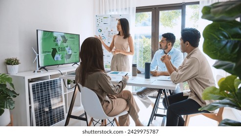 Asian woman lead young group of multiethnic businesspeople in team meeting, using laptop computer for ESG topic presentation on monitor. Sustainable business practice, people work at home concept - Powered by Shutterstock