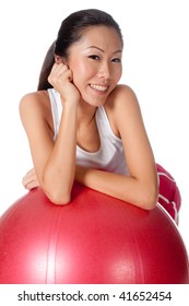 Asian Woman Leaning On Red Yoga Ball On White Background