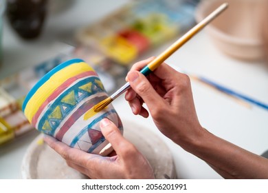 Asian woman learning color painting her self-made pottery at home. Confidence female enjoy hobbies and indoors leisure activity handicraft ceramic sculpture and painting workshop at pottery studio. - Shutterstock ID 2056201991
