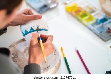 Asian woman learning color painting her self-made pottery at home. Confidence female relax and enjoy indoors lifestyle activity handicraft hobbies ceramic sculpture painting workshop at pottery studio - Powered by Shutterstock