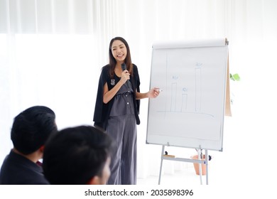 Asian woman Lecturer is lecturing about business and stock market topics and business people are interested in the knowledge in the economics class in meeting room at university.
