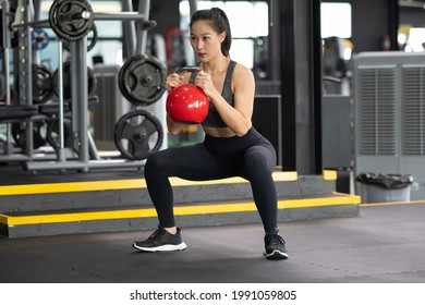 Asian Woman Lifts Single Kettlebell In Upper Arm Exercise To Build Muscle