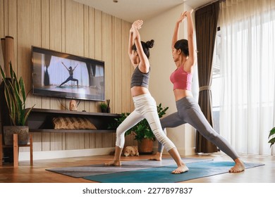 Asian woman and Little girl practicing yoga from yoga online course via smart TV at home

 - Powered by Shutterstock