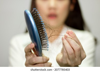 Asian Woman Look Hair Loss And Taking Hair From Blue Comb 