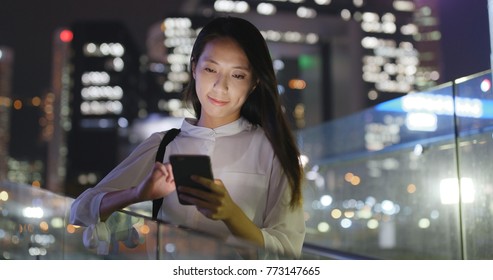 Asian Woman look at mobile phone in city at night  - Shutterstock ID 773147665