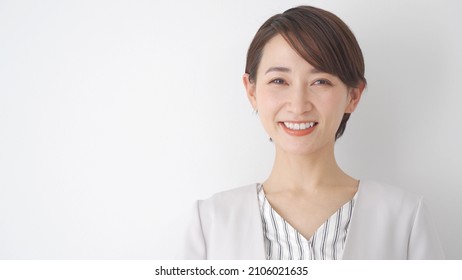 Asian woman looking at the camera with a smile
				