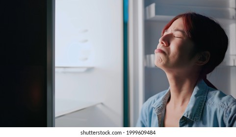 Asian Woman Looking At Empty Shelf In Fridge And She Feel Upset At Night