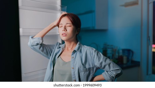 Asian Woman Looking At Empty Shelf In Fridge And She Feel Upset At Night