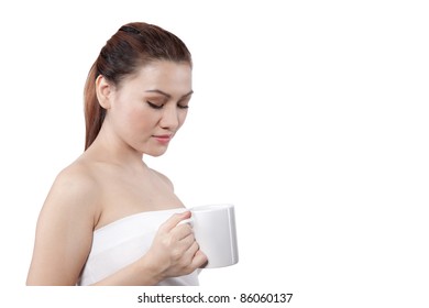 asian woman looking at her cup before she drinks