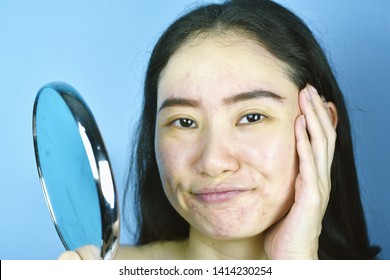 Asian Woman Looking At Herself In The Mirror, Female Feeling Annoy About Her Reflection Appearance Show The Aging Facial Skin Signs, Wrinkles, Dark Spot, Pimple, Acne Scar, Large Pores, Dull Skin.