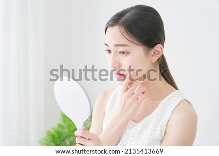Asian woman looking in the mirror