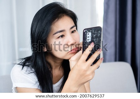 Asian woman looking at mobile phone screen too close to the eye ,social addiction , vision problem concept 