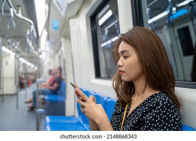 Asian Woman Looking At Smartphone Screen In Bangkok Subway MRT In Thailand.