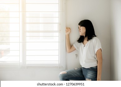 Asian Woman Looking Something On Window And Depression Have A Headache And Feeling Absent Minded In Bedroom